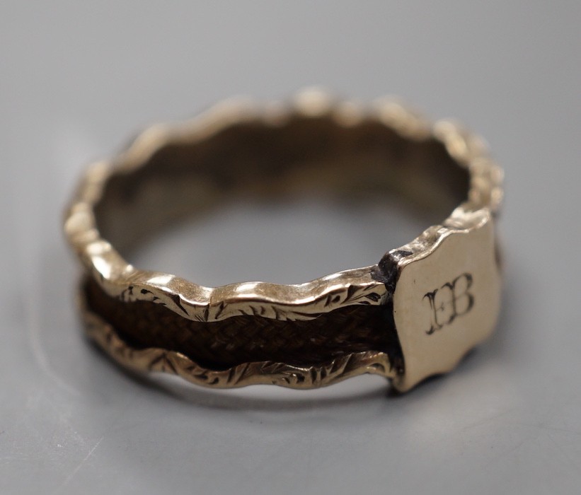 A 19th century yellow metal and plaited hair mourning band, with engraved initial, size N, gross weight 1.7 grams.